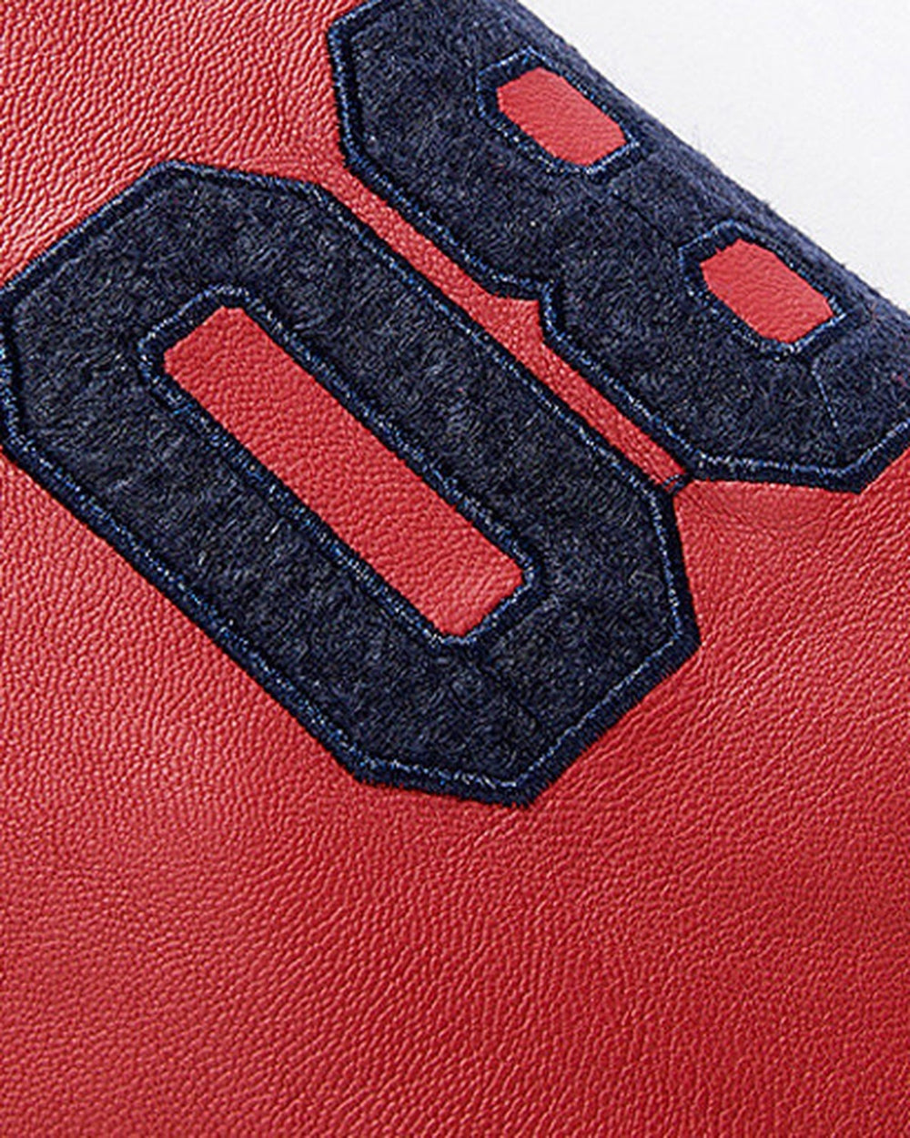 Close view of the navy chenille number patch on the red faux-leather sleeve