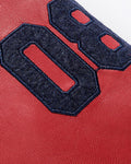 Close view of the navy chenille number patch on the red faux-leather sleeve
