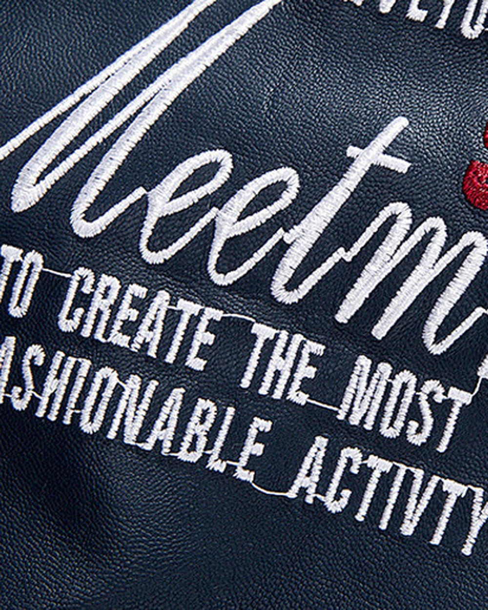 Close view of the white Meetmn script embroidery and red 95 on the navy jacket