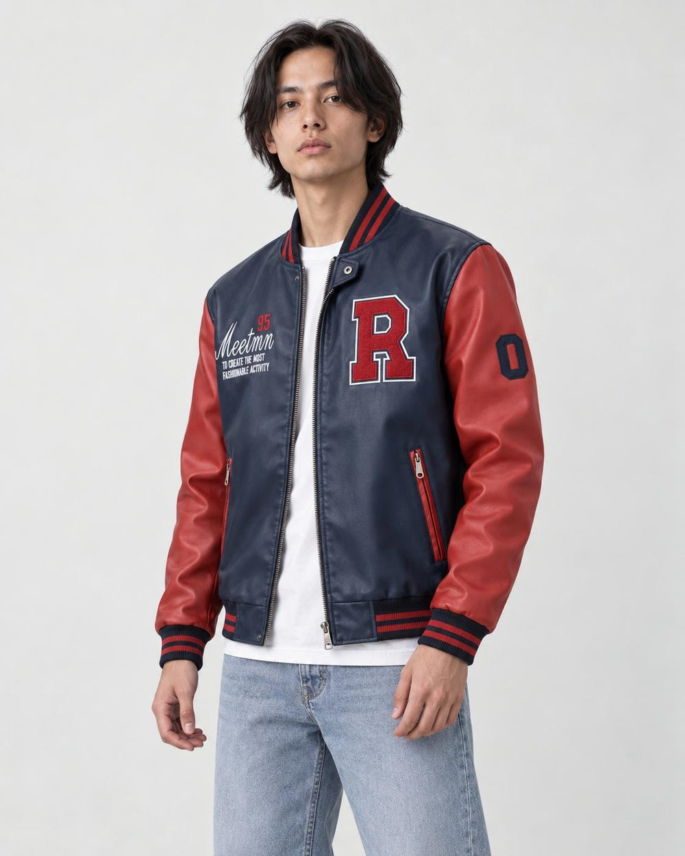 Man in the navy and red varsity jacket turned slightly, showing the sleeve patch and striped cuff
