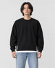 Model wearing the black raglan sweatshirt with a white layered hem and light-wash jeans, front view