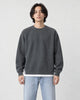Model wearing the dark gray raglan sweatshirt with a white layered hem and light-wash jeans, front view
