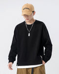 Black raglan sweatshirt in a relaxed pose, showing the ribbed cuffs and the white layered hem
