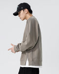 Taupe raglan sweatshirt from the side, showing the raglan seam and the white layered hem