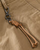 Close-up of the tan cord knotted to a metal snap hook on the belt loop of the khaki chinos