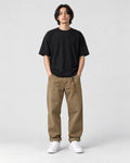 Model wearing the khaki cuffed chinos with a black tee and off-white sneakers, front view