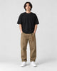 Model wearing the khaki cuffed chinos with a black tee and off-white sneakers, front view