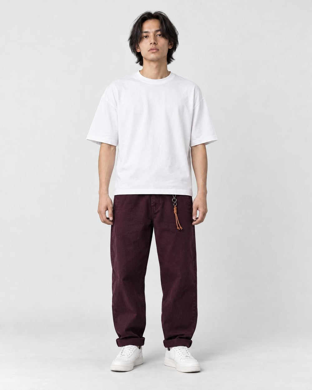 Model wearing the wine cuffed chinos with a white tee and off-white sneakers, front view