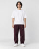 Model wearing the wine cuffed chinos with a white tee and off-white sneakers, front view