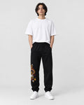 Model wearing the black gold dragon joggers with a white T-shirt, front view