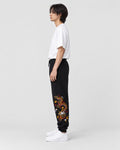 Model wearing the black gold dragon joggers with a white T-shirt, side view
