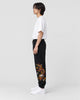 Model wearing the black gold dragon joggers with a white T-shirt, side view
