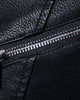 Close-up of the chest zip pocket and diagonal zip on the black biker jacket