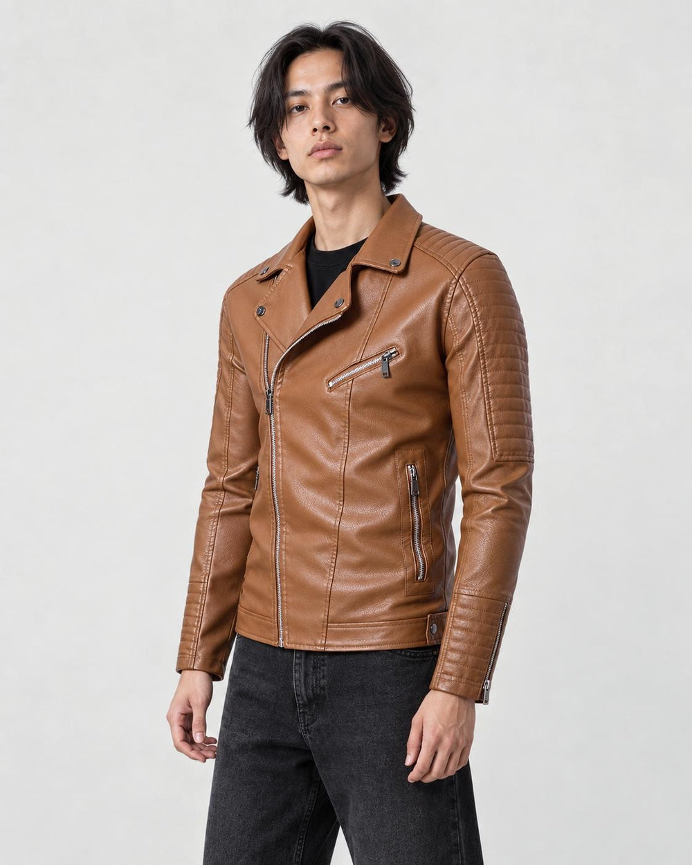 Man in a tan-brown leather-look biker jacket with an asymmetric zip over a black tee, three-quarter view