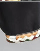 Close-up of the turned-up cuff lined with woven jacquard on the black denim shorts