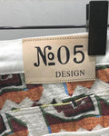Close-up of the tan No.05 DESIGN patch and the woven jacquard at the back waistband