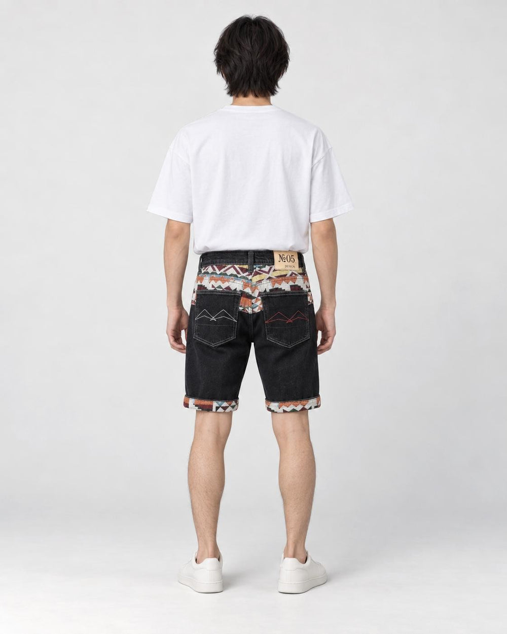 Model wearing the black stretch denim shorts with a white tee, seen from behind, with the jacquard yoke