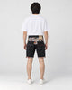 Model wearing the black stretch denim shorts with a white tee, seen from behind, with the jacquard yoke