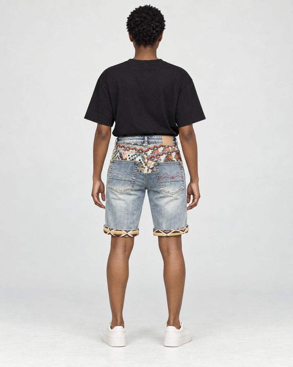 Model wearing the light blue washed denim shorts with a black tee, seen from behind, with the jacquard yoke