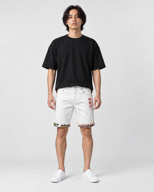 Model wearing the white stretch denim shorts with a black tee and white sneakers, front view