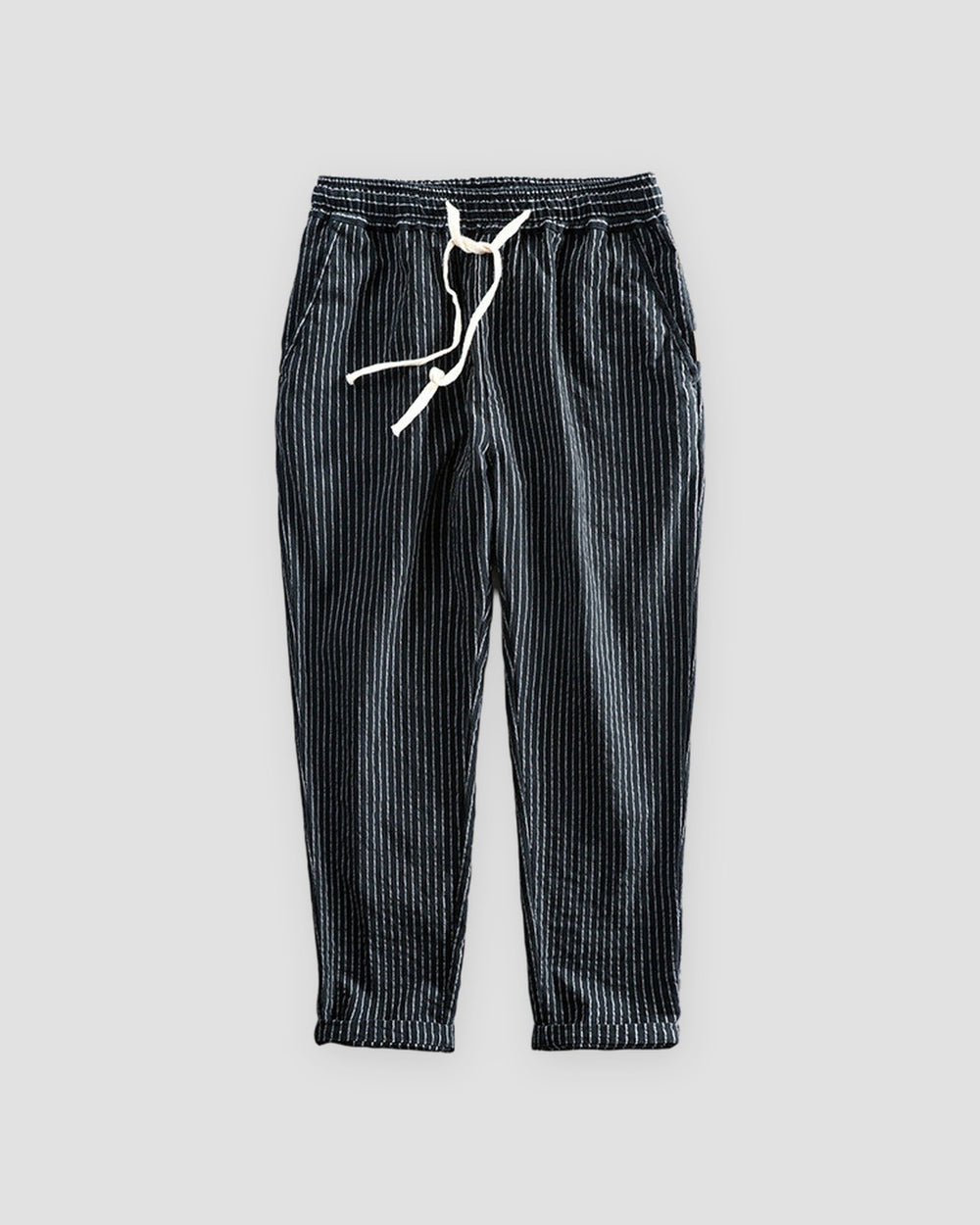 Black striped cropped pants with a cream drawstring and turned-up cuffs, flat view