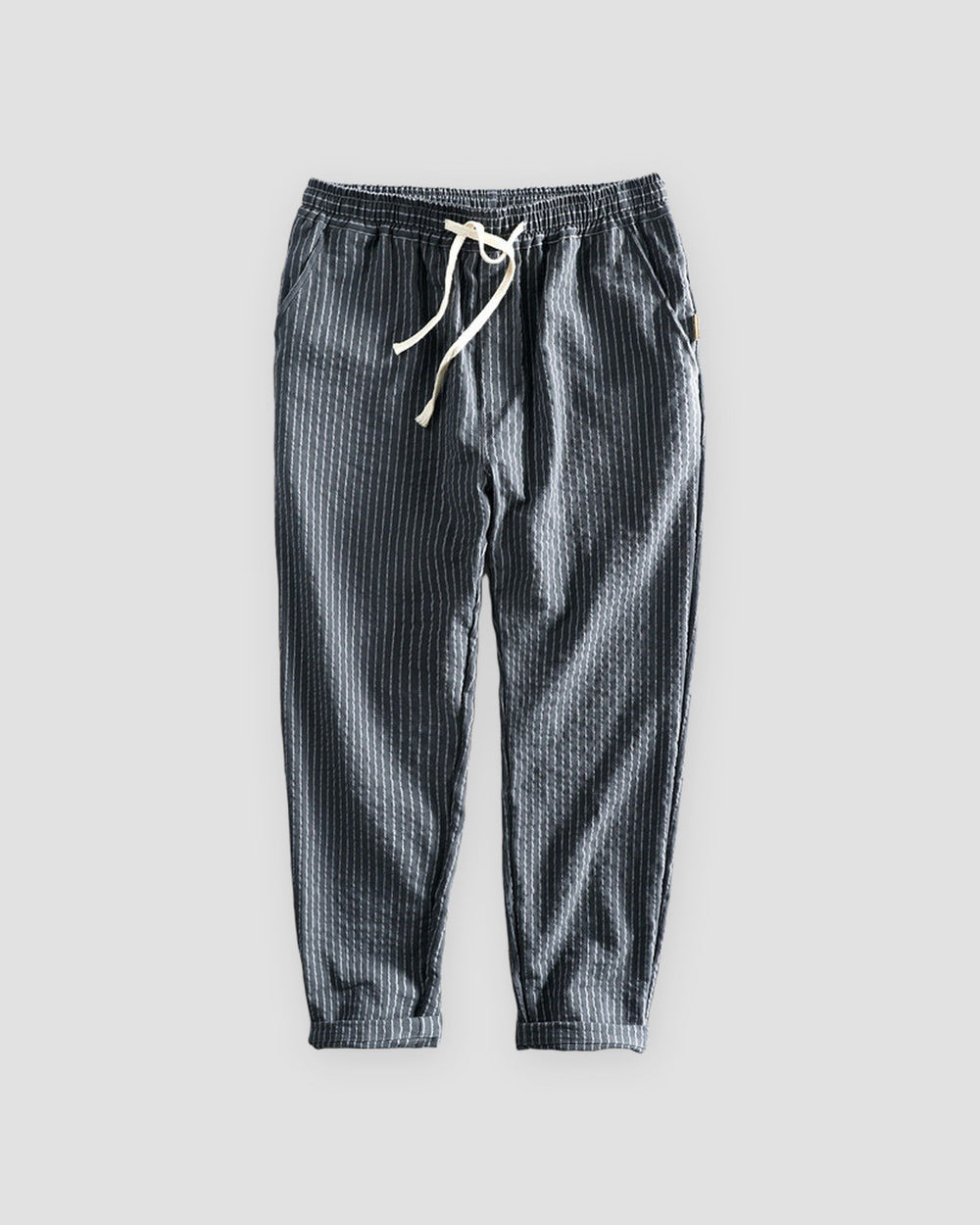 Dark gray striped cropped pants with a cream drawstring and turned-up cuffs, flat view