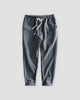 Dark gray striped cropped pants with a cream drawstring and turned-up cuffs, flat view