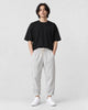 Model wearing the white striped cropped pants with a black tee and off-white sneakers, front view