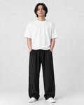 Model wearing the black wide-leg linen pants with a white tee and white sneakers, front view