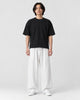 Model wearing the white wide-leg linen pants with a black tee and white sneakers, front view