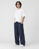 Model wearing the navy wide-leg linen pants with a white tee and white sneakers, three-quarter view