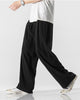 Black wide-leg linen pants in motion, showing the long straight leg and the soft drape