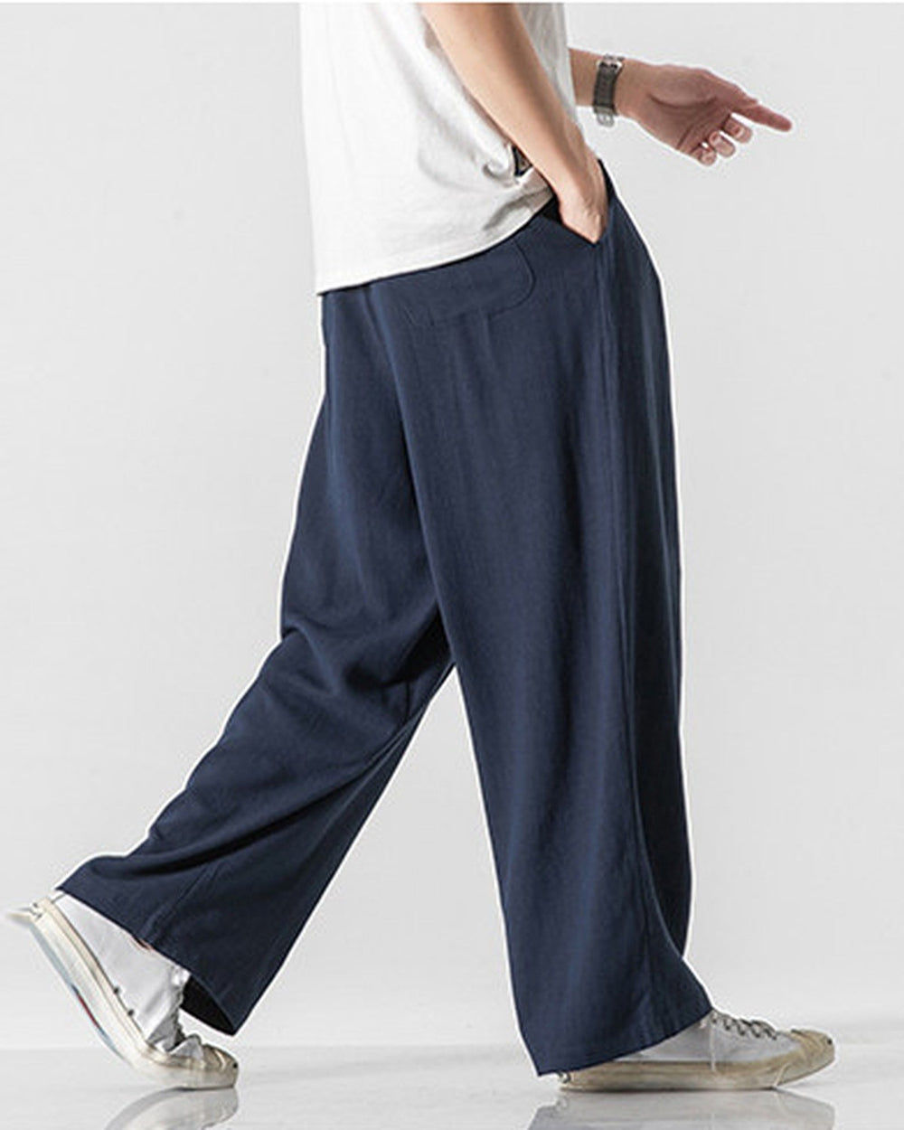 Navy wide-leg linen pants in motion, showing the long straight leg and the soft drape
