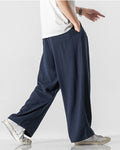 Navy wide-leg linen pants in motion, showing the long straight leg and the soft drape