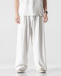 White wide-leg linen pants with an elastic drawcord waist, worn with a white tee and canvas sneakers