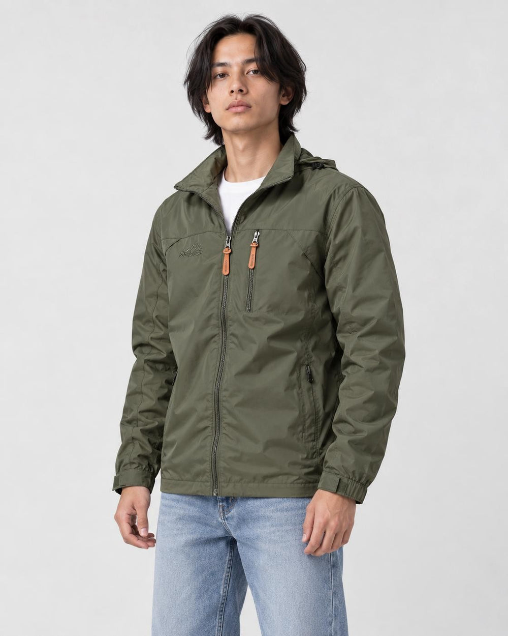 Model wearing the army green windbreaker jacket over a white tee with light-wash jeans, three-quarter crop