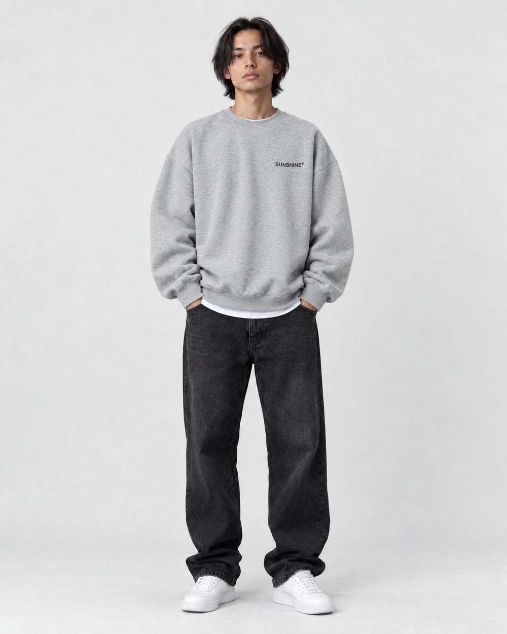 Model wearing the light gray sweatshirt with a small black chest print
