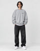 Model wearing the light gray sweatshirt with a small black chest print