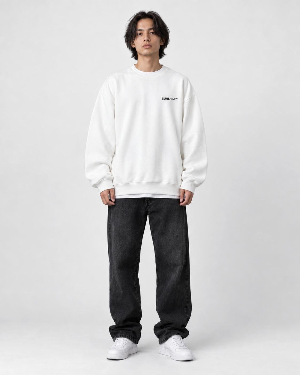 Model wearing the white sweatshirt with a small black chest print