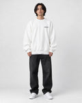 Model wearing the white sweatshirt with a small black chest print
