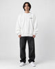 Model wearing the white sweatshirt with a small black chest print