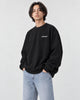 Model wearing the black chest print sweatshirt, three-quarter view