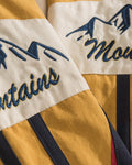 Close-up of the Mountains script and snowy peaks embroidered on the sleeve