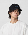 Model wearing the black mountain sunrise cap, three-quarter view