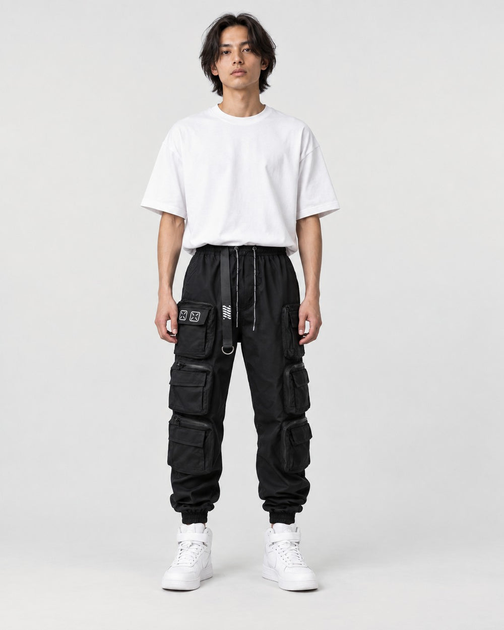 Model wearing the black multi-pocket techwear cargo pants, front view
