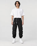 Model wearing the black multi-pocket techwear cargo pants, front view