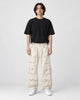 Model wearing the beige multi-pocket cargo pants with a black tee, front view