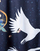 Close view of a white crane in flight on the dark navy fabric with a gold ring and small teal flecks