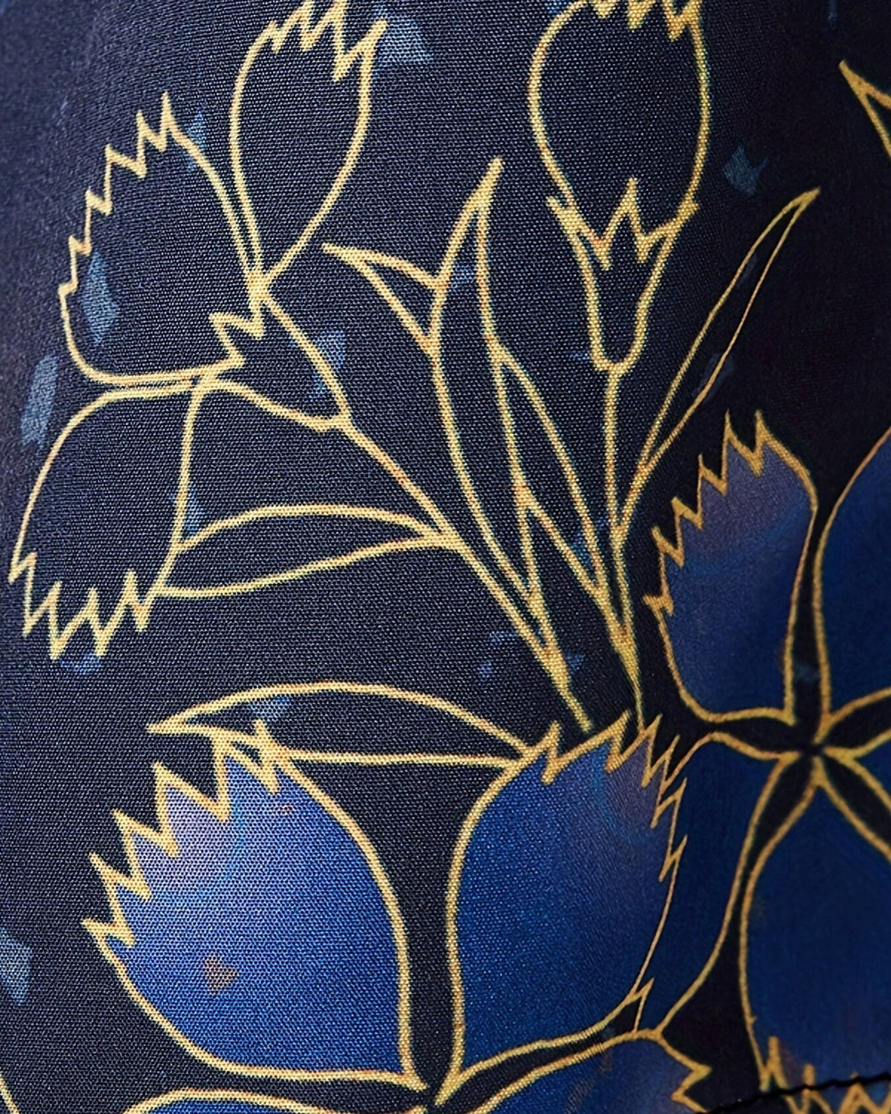 Close view of blue flowers with gold outlines on the dark navy haori