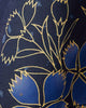 Close view of blue flowers with gold outlines on the dark navy haori